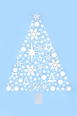 Fantasy Christmas tree concept shape with joy sign, abstract snow, tree bauble star and snowflake ornaments on pastel  blue background. Magical design for winter, Xmas, New Year.