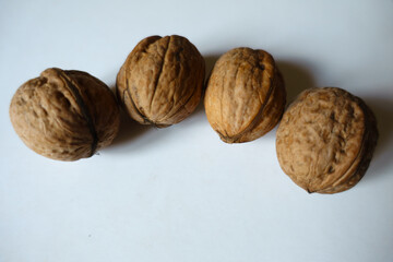Batch of four ripe brown rounded wrinkly fruits of Persian walnut
