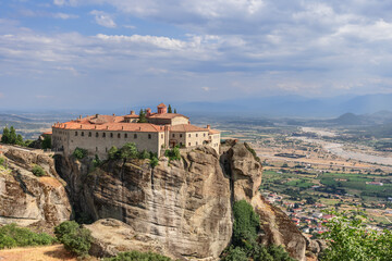 Fototapeta na wymiar View of Thessaly valley with Kalabaka townr and historic Eastern Orthodox St. Stephen Holy Monastery nestled on a rocky plateau, Meteora, Greece.