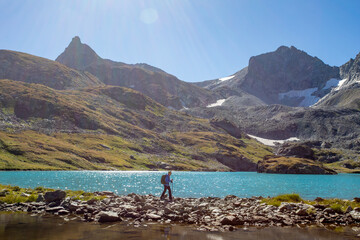 Fototapeta na wymiar The girl rises uphill against the background of a blue turquoise lake. Mountain landscape. A place for a healthy lifestyle. Caucasus, Russia