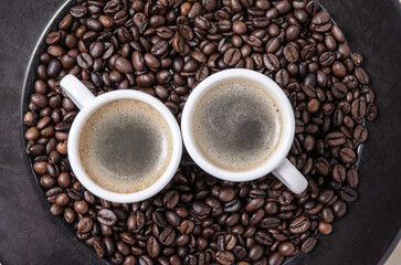 Coffee espresso beans on dark background plate and cups with crema, close-up, flat lay background still life hot beverage, I love coffee concept