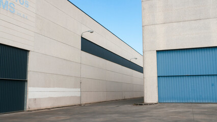 Fototapeta na wymiar Puerta metálica azul en nave industrial de hormigón 