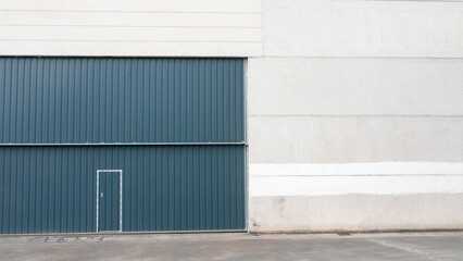 Puerta metálica azul en nave industrial de hormigón 