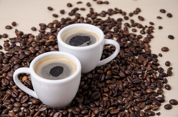 Roasted coffee espresso beans on dark background and two cups with crema, close-up, flat lay background still life hot beverage, I love coffee concept