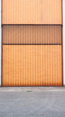 Puerta metálica naranja en nave industrial de hormigón 