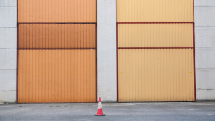 Puerta metálica naranja en nave industrial de hormigón 