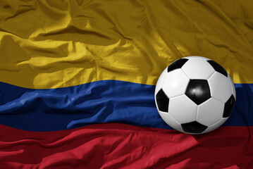 vintage football ball on the waveing national flag of colombia background. 3D illustration
