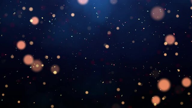 abstract background of the new year festival celebration slow moving particles and confetti on dark blue background.