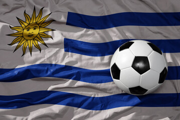 vintage football ball on the waveing national flag of uruguay background. 3D illustration