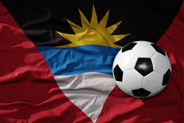 Naklejka premium vintage football ball on the waveing national flag of antigua and barbuda background. 3D illustration