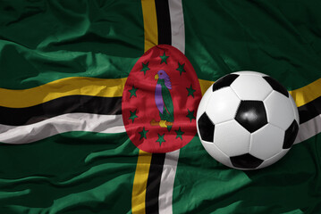 vintage football ball on the waveing national flag of dominica background. 3D illustration