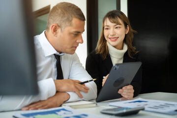 Businessmen write project ideas and use laptops to edit papers for brainstorming sessions with partners in the office.