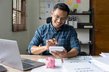 Businessman working with financial data hand using calculator and piggy saving. Business financial and accounting concept.