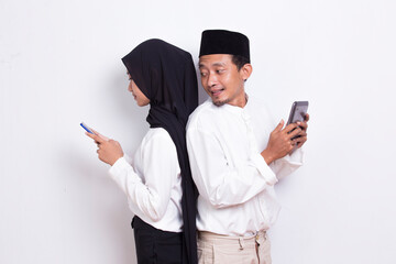 young asian muslim couple spying and peeking at smartphone isolated on white background