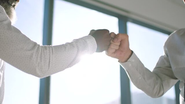 Business men, fist bump or handshake with friends or staff greeting or celebration for victory, success and achieving goals together as team. Hands of male partners in office to welcome and support