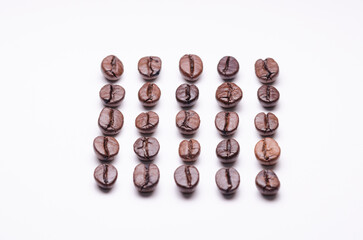 Rows of coffee beans order aligned, organization concept, close-up macro still life on white background