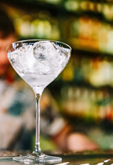 Ice cube in an empty glass on a bar counter in bar or pub
