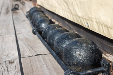 The balls cores for cannon of the 18th century on the desk of old sail battleship