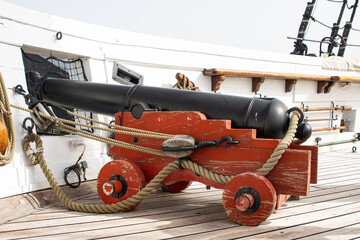 Historirical retro metal cannon on battle sailing vessel