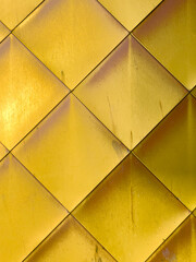 Golden yellow brass tiles wall background.