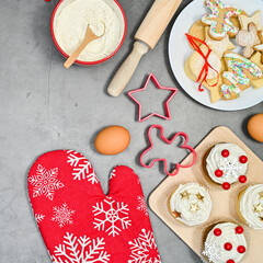 Christmas cookies and cupcakes with ingredients for baking on the table. Flat lay