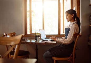 Female, coffee shop owner and laptop restaurant worker on a work break on a laptop. Happy smile of waiter employee online at a cafe using technology on the internet reading a job email with happiness