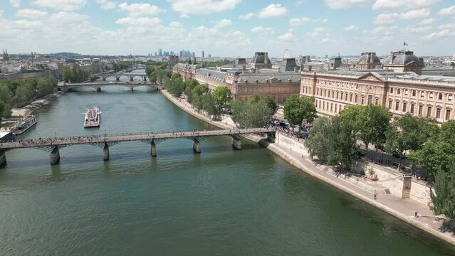 Aeril forward over Pont des Arts on river Seine and Centre Dominique-Vivant Denon, Louvre Museum, Paris