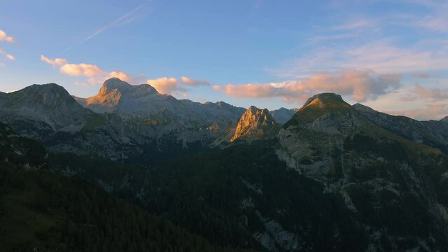 moving drone footage filmed up the Slovenian mountains in the Alps filmed in 4k wide lens, showing beautiful mountains, nature, and sky at sunset