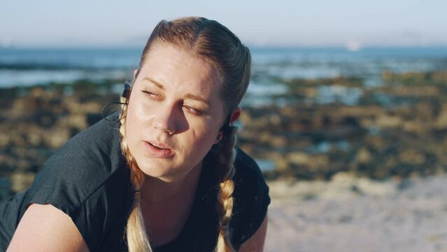 Tired, fitness and breathing overweight woman runner on beach for body motivation, healthy lifestyle and wellness. Girl and audio music for exercise, workout or training goals by sea ocean in morning