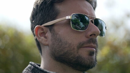 Young man wearing sunglasses outdoors. Portrait face closeup of handsome male person with cool eye glass