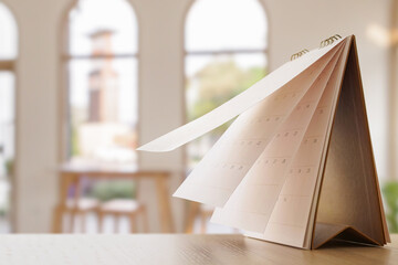 desk calendar on table with blurred bokeh background appointment and business meeting concept