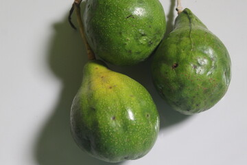 three unripe avocados on the floor
