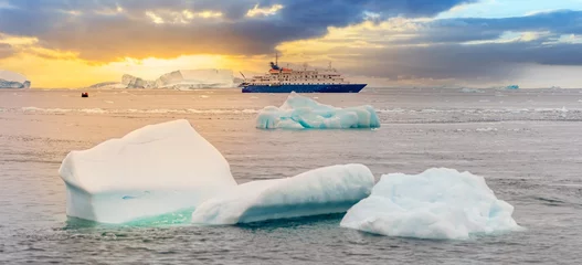 Badezimmer Foto Rückwand blaues Expeditionsschiff vor antarktischer Eisberg Landschaft in der Cierva Cove - ein tiefer Meeresarm an der Westseite der Antarktischen Halbinsel, umringt von dramatischen Gletscherfronten © stylefoto24