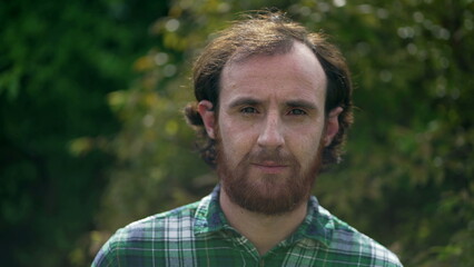 Fototapeta premium Happy man closeup face. Portrait of a redhead casual male person standing outdoors in nature