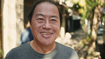Closeup face of a Japanese man standing in street looking at camera. Middle aged Asian person © Marco
