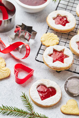 Classic Linzer Christmas Cookies with raspberry or strawberry jam on light background.