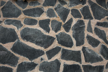 Mauer mit großen schwarzen Steinen als Textur oder Hintergrund