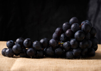 black grapes in a basket on a brown wicker background