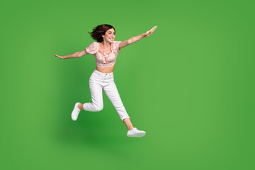 Fototapeta na wymiar Full length photo of sweet adorable lady wear print top jumping high looking empty space isolated green color background