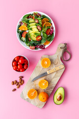 Cooking healthy green salad with avocado and tomatoes