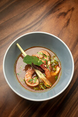 thai tom yam kung spicy soup with prawns on wood table