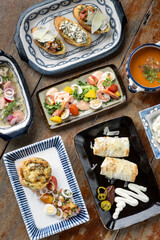selection of many different tapas on rustic wood table