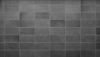 Front view of a new and modern wall or building exterior made of gray slabs. Abstract full frame background in black and white.