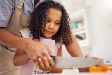 Father with kid helping her in the kitchen and cooking food together. Dad helps girl chop vegetable or fruit for healthy meal for lunch. Child development, teaching and learning how to cook at home