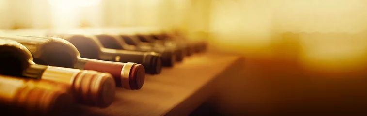 Rolgordijnen Flessen rode wijn op een houten plank. bannerachtergrond voor wijnmakerij, bar of winkel © Konstiantyn
