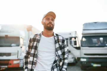 Standing against beautiful sunlight. Young truck driver is with his vehicle at daytime © standret