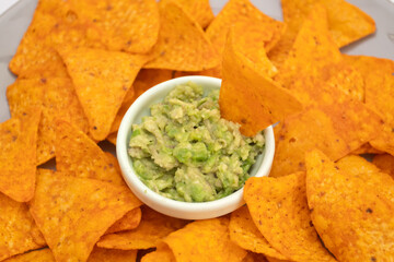 Guacamole dip and nachos on a plate