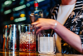 woman hand bartender making negroni cocktail in bar