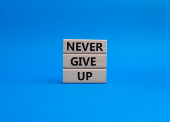 Never give up symbol. Concept words Never give up on wooden blocks. Beautiful blue background. Business and Never give up concept. Copy space.