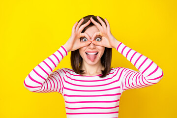 Photo portrait of pretty young lady tongue out fingers show okey glasses dressed stylish striped outfit isolated on yellow color background